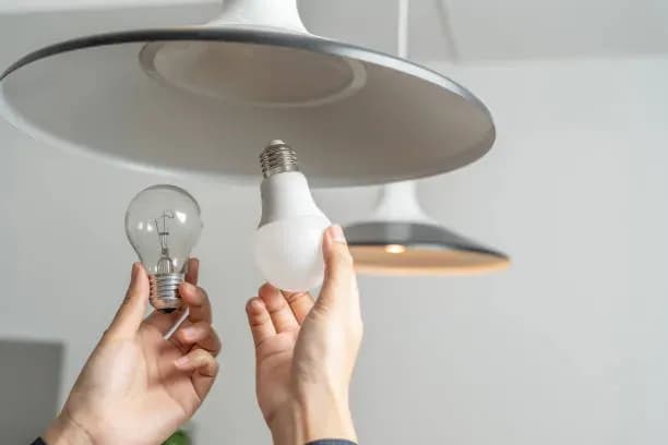 Una imagen donde se ve a una persona que está haciendo el cambio de foco atendiendo a la importancia del ahorro de energía.